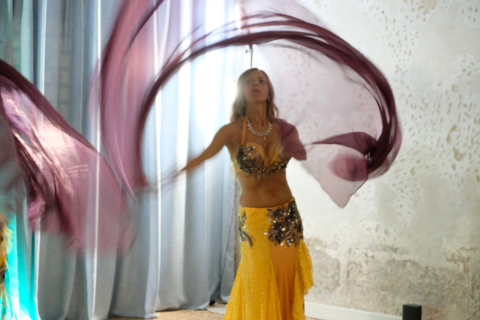 Danzatrice con un velo in movimento accanto a una finestra
