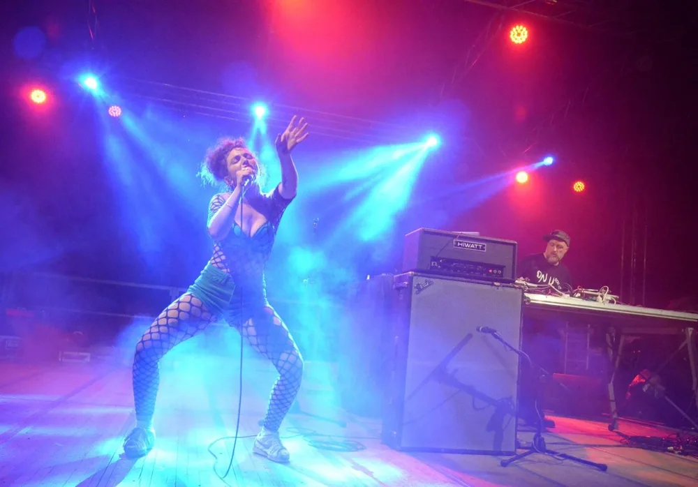 Musicista sul palco tra luci blu e magenta