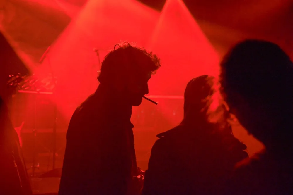 Silhouette di persone nella luce rossa di un locale